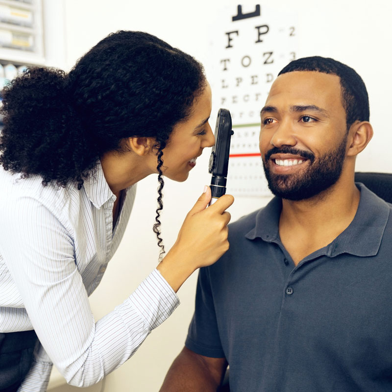 An optometrist checking a man's eyes